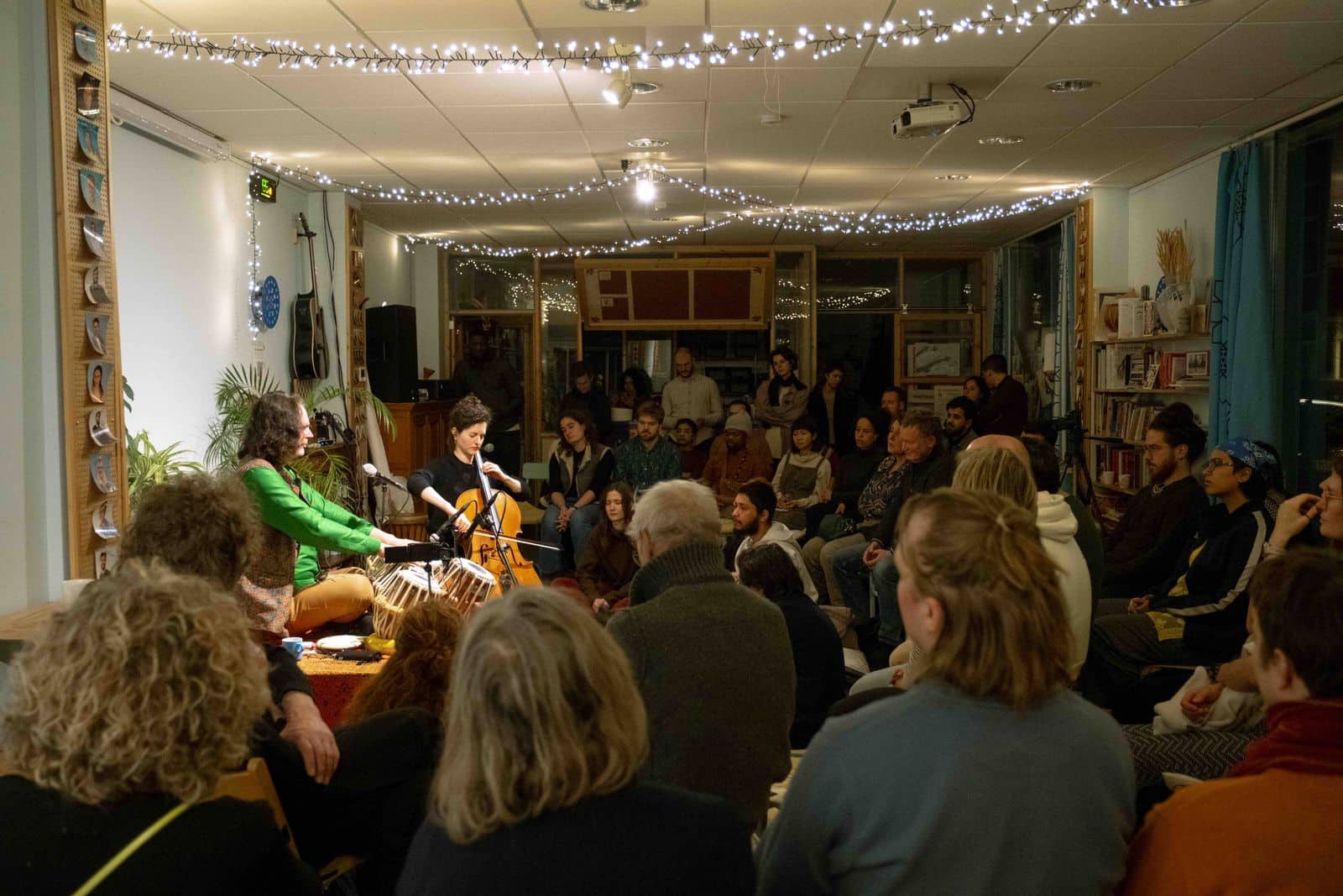 Musicians playing cello and tabla to a seated audience during a Culture Shock concert.